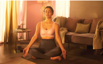 A confident woman wearing a soft-cup bra, smiling in natural light.